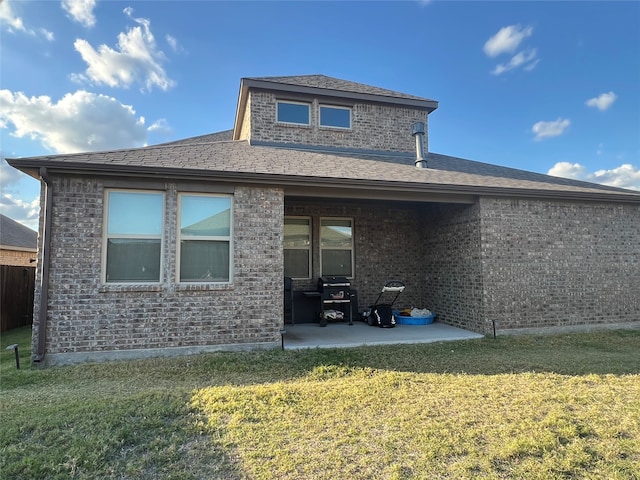 rear view of property featuring a patio area and a lawn