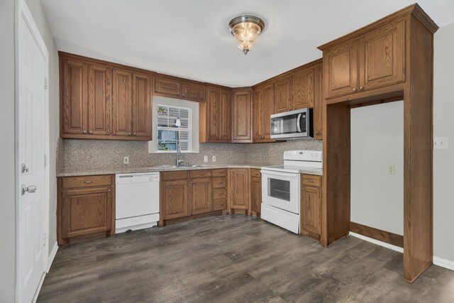 kitchen featuring white dishwasher, sink, dark hardwood / wood-style floors, and backsplash