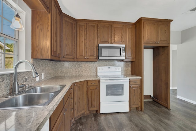 kitchen with decorative backsplash, dark hardwood / wood-style flooring, ceiling fan, sink, and white appliances