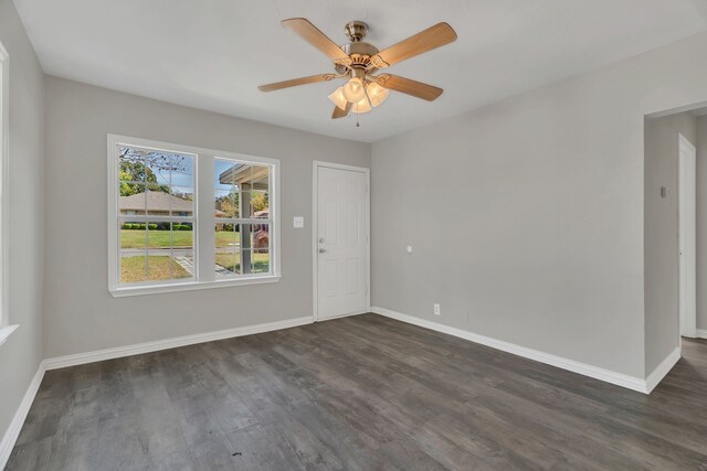 unfurnished room featuring ceiling fan, a wealth of natural light, and dark hardwood / wood-style floors