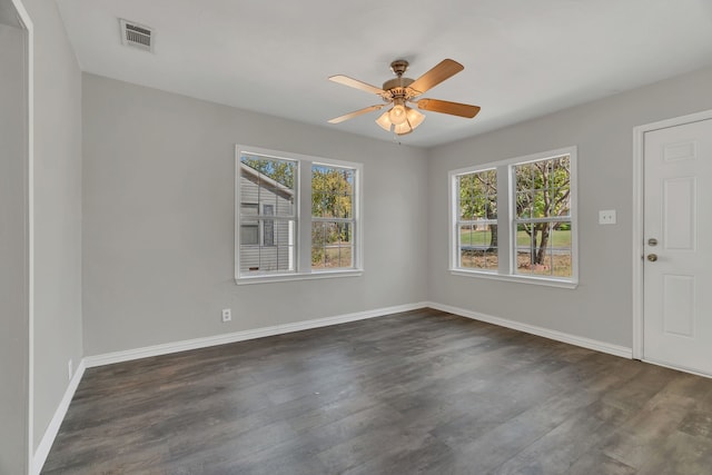 empty room featuring dark wood-type flooring and ceiling fan