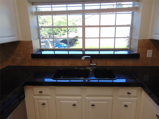 kitchen with white cabinets, dishwasher, sink, and backsplash