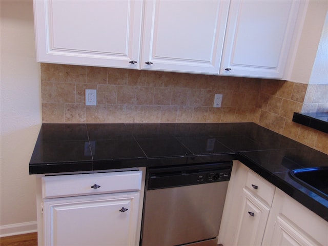 kitchen featuring white cabinets, stainless steel dishwasher, wood-type flooring, and backsplash