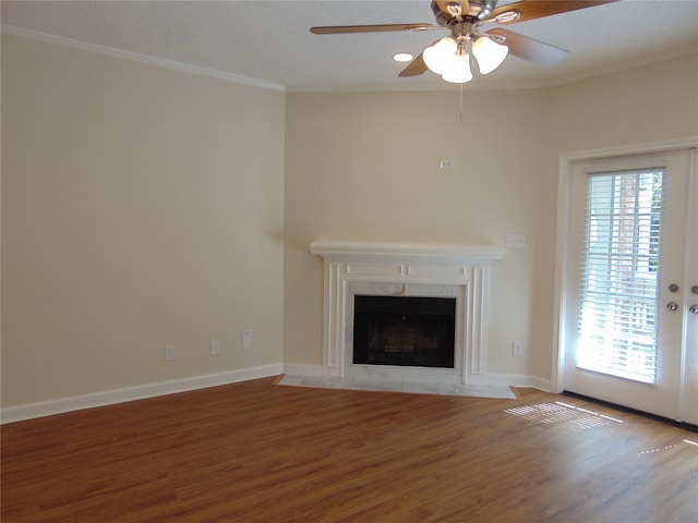 unfurnished living room with ceiling fan, crown molding, a high end fireplace, and hardwood / wood-style floors