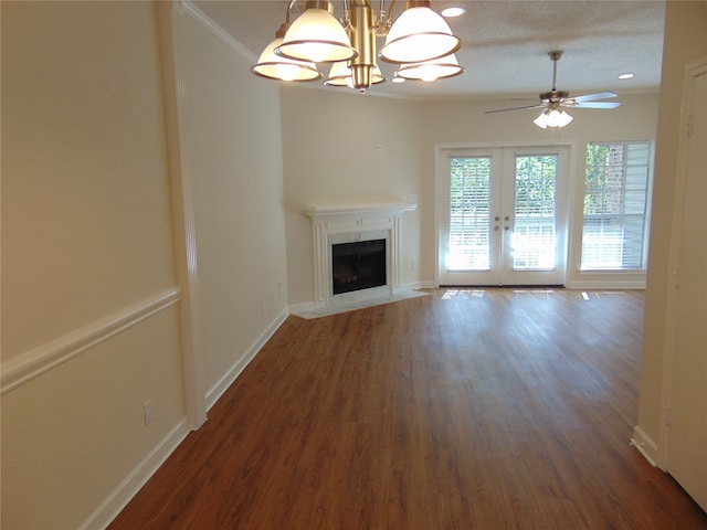 unfurnished living room with french doors, a textured ceiling, crown molding, dark hardwood / wood-style floors, and ceiling fan with notable chandelier