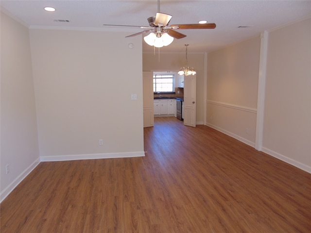 empty room with ornamental molding, sink, dark wood-type flooring, and ceiling fan with notable chandelier