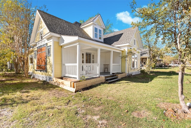 exterior space featuring covered porch and a front lawn