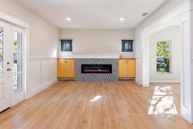 unfurnished living room with a fireplace and light wood-type flooring