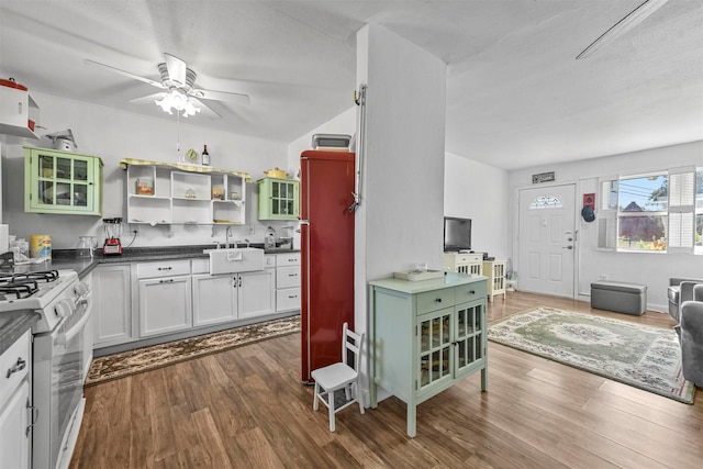 kitchen featuring hardwood / wood-style floors, white cabinetry, and white stove