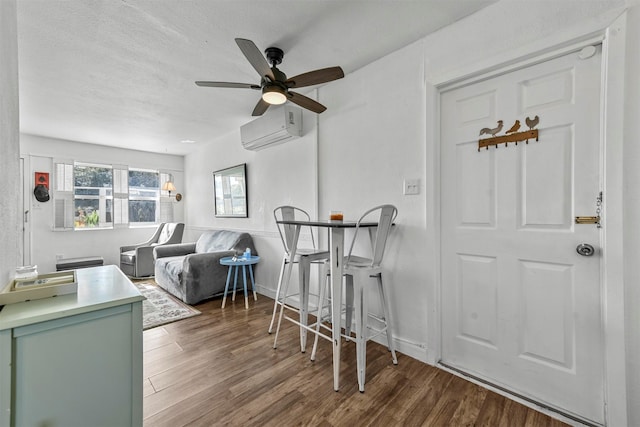 living room featuring ceiling fan, a textured ceiling, a wall mounted air conditioner, and hardwood / wood-style floors