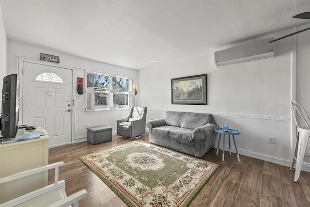 living room featuring a textured ceiling, an AC wall unit, and dark hardwood / wood-style flooring