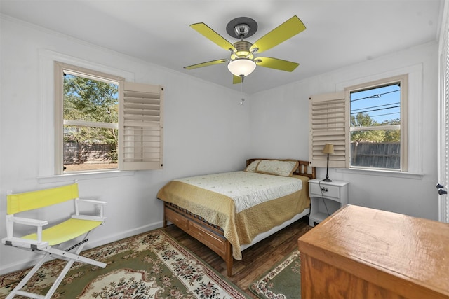 bedroom with crown molding, dark hardwood / wood-style floors, and ceiling fan