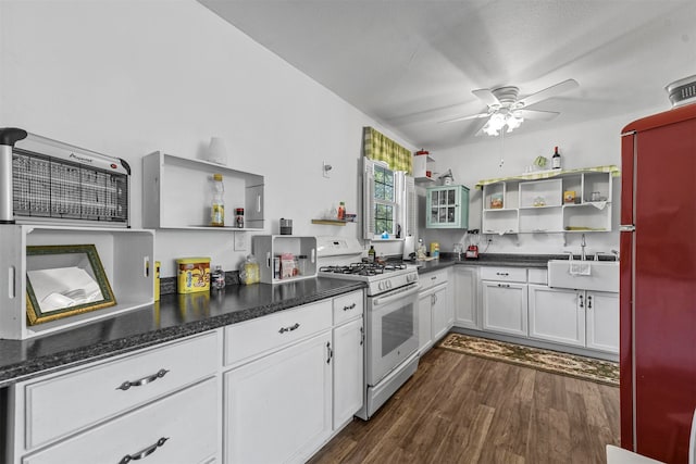 kitchen featuring fridge, white gas range, ceiling fan, white cabinetry, and dark wood-type flooring