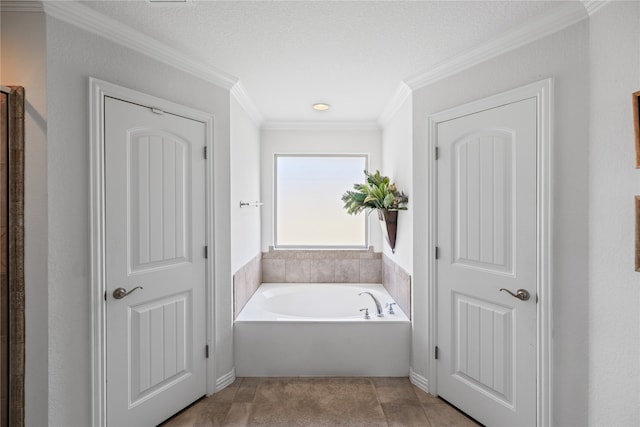 bathroom featuring crown molding, a washtub, a textured ceiling, and tile patterned flooring