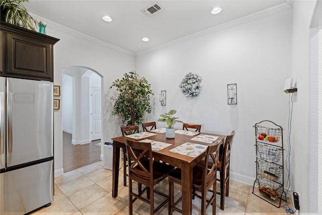 tiled dining space featuring ornamental molding