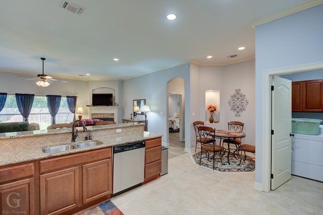 kitchen with crown molding, washer / clothes dryer, stainless steel dishwasher, and sink