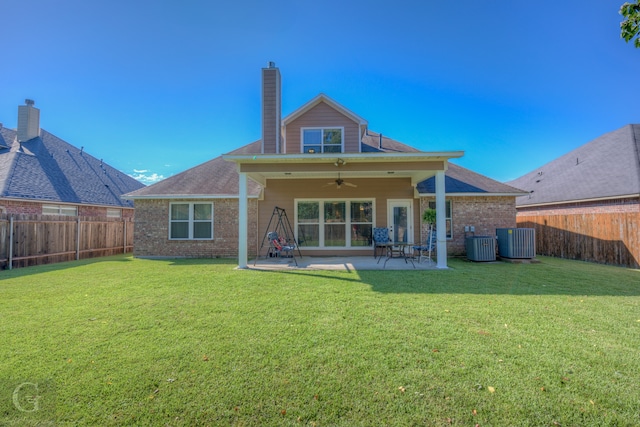 rear view of property featuring central air condition unit, a patio, a lawn, and ceiling fan