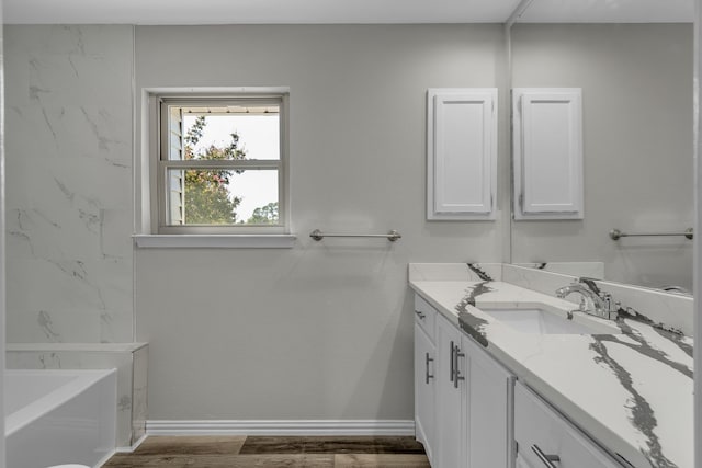 bathroom with vanity, a tub to relax in, and wood-type flooring