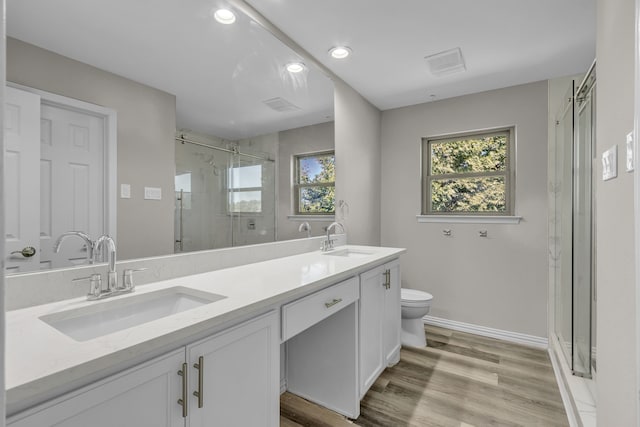 bathroom featuring toilet, an enclosed shower, hardwood / wood-style floors, and vanity