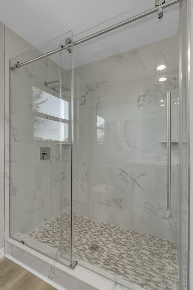 bathroom featuring a shower with door and hardwood / wood-style flooring