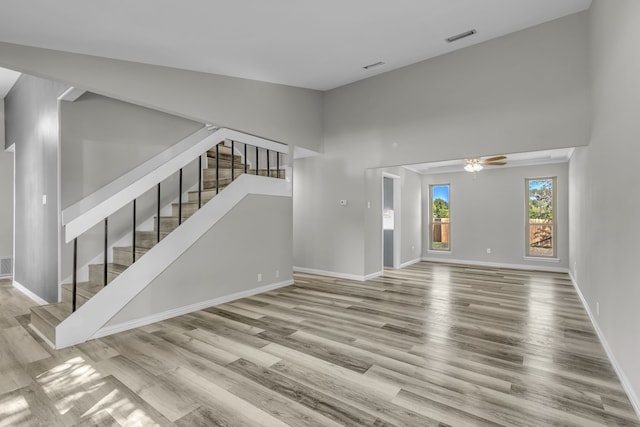 unfurnished living room featuring light hardwood / wood-style floors, ceiling fan, and vaulted ceiling