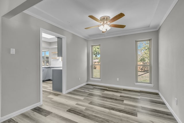 unfurnished room with light hardwood / wood-style flooring, plenty of natural light, and crown molding