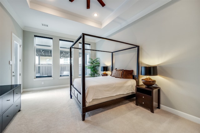 carpeted bedroom featuring ceiling fan, ornamental molding, and a tray ceiling