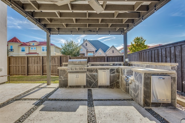 view of patio featuring an outdoor kitchen and a grill