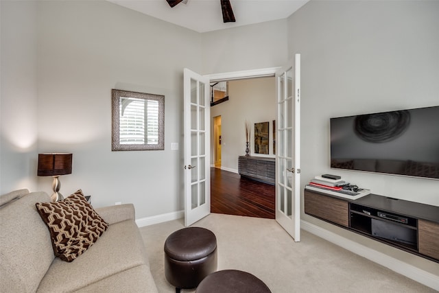 carpeted living room with ceiling fan and french doors