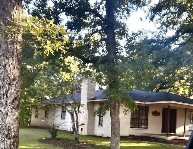 rear view of property featuring a yard