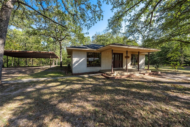 view of front of property featuring a carport and a front lawn