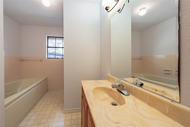 bathroom with vanity, a bath, and tile walls