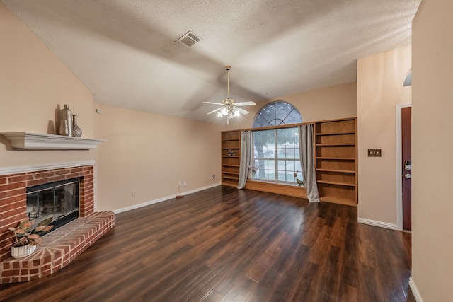 unfurnished living room with lofted ceiling, dark wood-type flooring, a brick fireplace, a textured ceiling, and ceiling fan