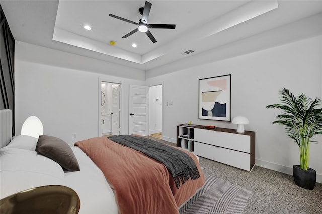 bedroom with carpet, a raised ceiling, ceiling fan, and ensuite bath