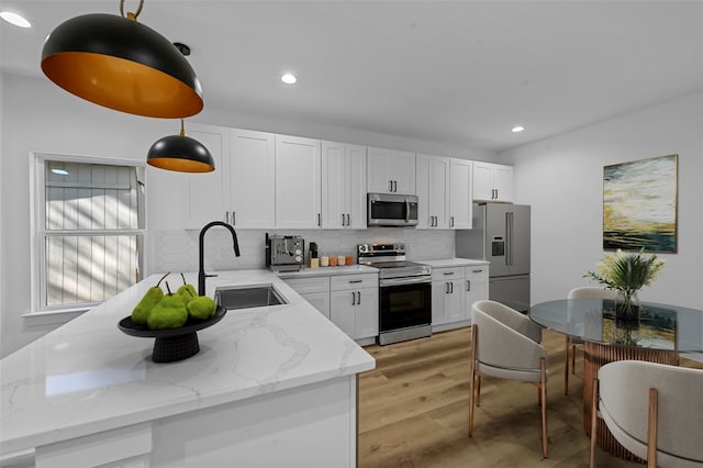 kitchen featuring white cabinetry, pendant lighting, appliances with stainless steel finishes, and sink