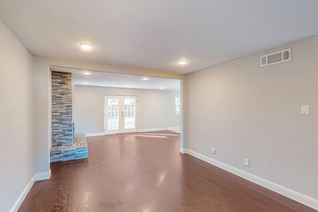 unfurnished living room featuring dark wood-type flooring and french doors