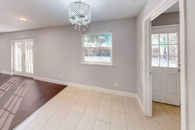 interior space featuring french doors, a notable chandelier, and light hardwood / wood-style flooring