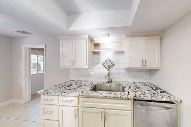 kitchen with tasteful backsplash, light stone counters, light tile patterned floors, stainless steel dishwasher, and sink