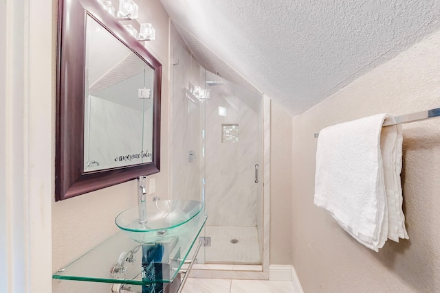 bathroom featuring a shower with door, tile patterned floors, sink, and a textured ceiling