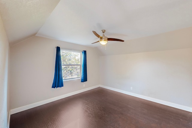 empty room with lofted ceiling, dark hardwood / wood-style floors, and ceiling fan