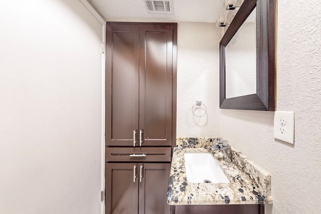 bathroom with vanity and a textured ceiling