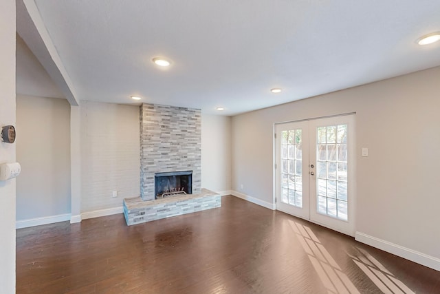 unfurnished living room with french doors, a fireplace, and dark hardwood / wood-style floors