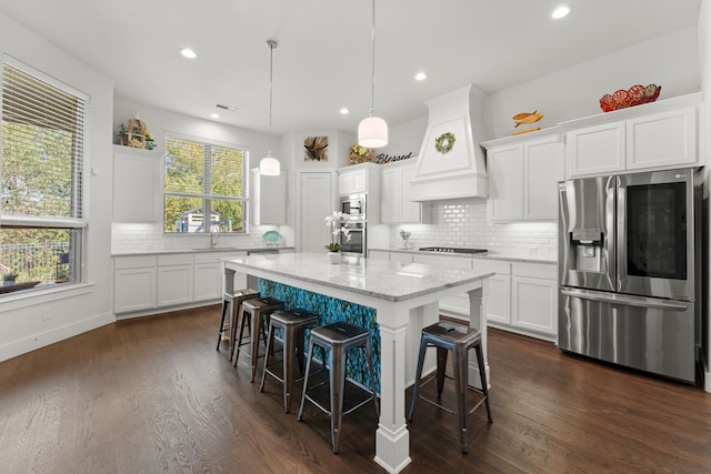 kitchen featuring a kitchen island, white cabinetry, and stainless steel appliances