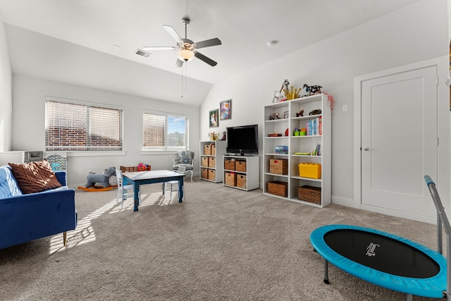 playroom with ceiling fan, light colored carpet, and vaulted ceiling