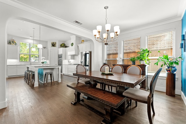 dining room with a notable chandelier, dark wood-type flooring, and crown molding