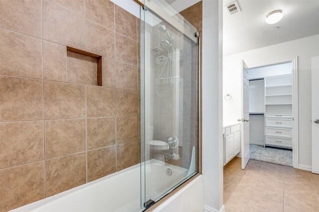 575 S Virginia Hills Dr Unit 3004, Mckinney, TX 75072 - full bathroom with bath / shower combo with glass door, tile patterned flooring, vanity, baseboards, and a walk in closet