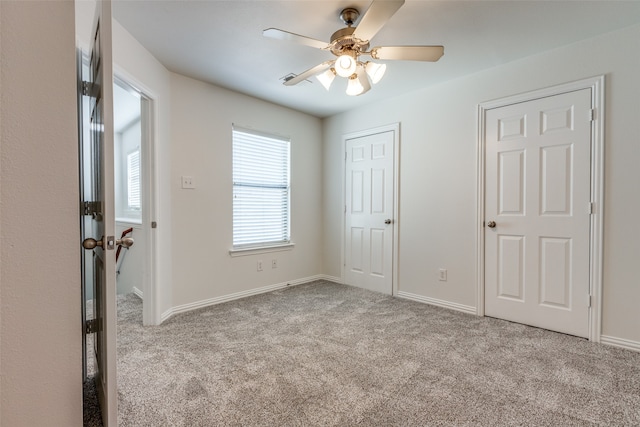 unfurnished bedroom with ceiling fan and light colored carpet