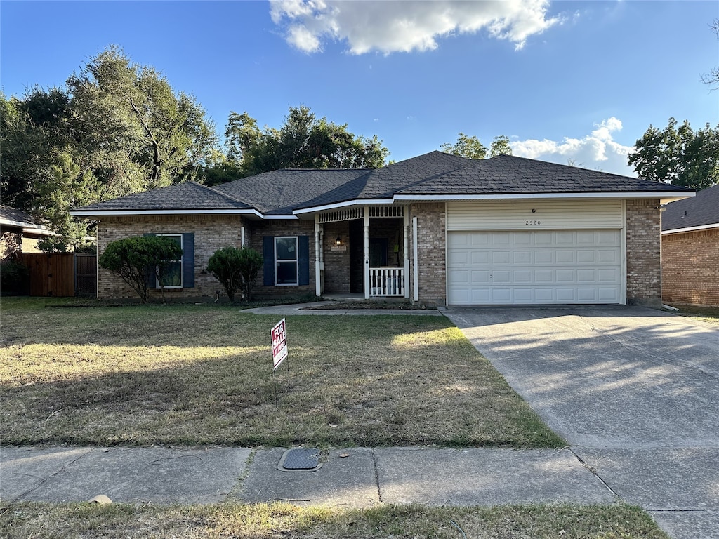 single story home featuring a front lawn and a garage