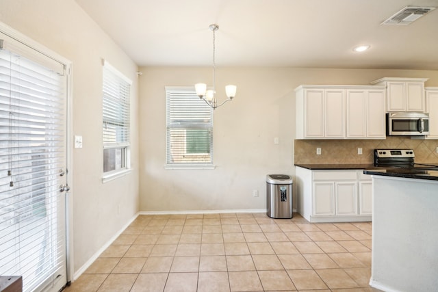 kitchen featuring hanging light fixtures, backsplash, white cabinets, light tile patterned floors, and appliances with stainless steel finishes