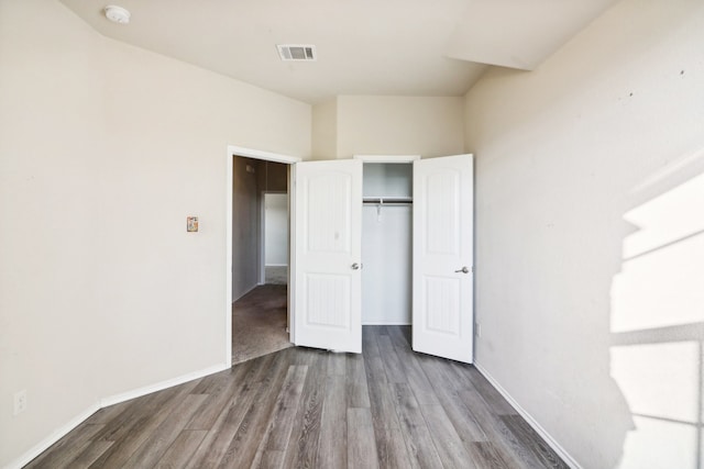 unfurnished bedroom featuring wood-type flooring and a closet